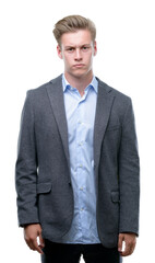 Young handsome blond business man skeptic and nervous, frowning upset because of problem. Negative person.