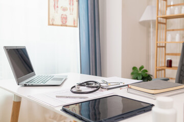 stethoscope is placed on work desk in doctor office After examining patient stethoscope is placed on the work desk to examine additional information from the computer that has compiled the results.