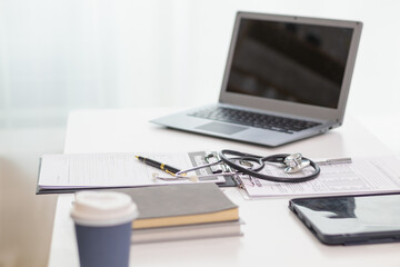 stethoscope is placed on work desk in doctor office After examining patient stethoscope is placed on the work desk to examine additional information from the computer that has compiled the results.