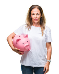 Middle age hispanic woman saving money using piggy bank over isolated background with a confident...