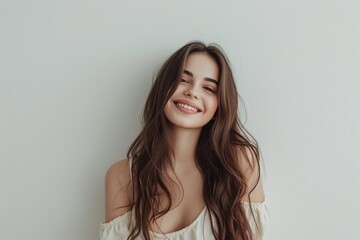 Fototapeta premium Young attractive brunette standing against a white wall