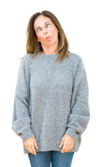 Beautiful middle age woman wearing winter sweater over isolated background making fish face with lips, crazy and comical gesture. Funny expression.