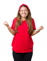 Young beautiful brunette woman wearing red t-shirt over isolated background celebrating surprised and amazed for success with arms raised and open eyes. Winner concept.