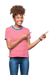 Beautiful young african american woman over isolated background smiling and looking at the camera pointing with two hands and fingers to the side.