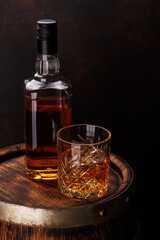 Whiskey glass with ice on a rustic barrel, a classic sip