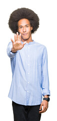 Young african american man with afro hair doing stop sing with palm of the hand. Warning expression with negative and serious gesture on the face.