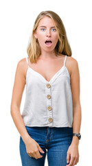 Beautiful young woman over isolated background In shock face, looking skeptical and sarcastic,...