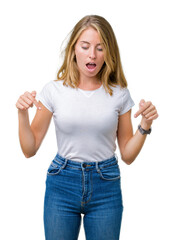 Beautiful young woman wearing casual white t-shirt over isolated background Pointing down with fingers showing advertisement, surprised face and open mouth