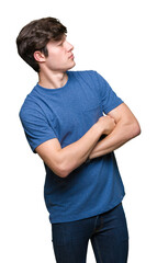 Young handsome man wearing blue t-shirt over isolated background smiling looking to the side with arms crossed convinced and confident