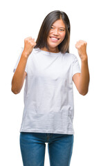 Young asian woman over isolated background very happy and excited doing winner gesture with arms raised, smiling and screaming for success. Celebration concept.