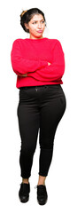 Young beautiful woman wearing red sweater and bun smiling looking to the side with arms crossed convinced and confident