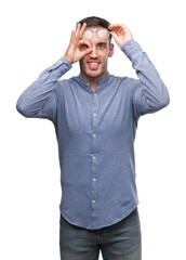 Fototapeta premium Handsome young elegant man wearing glasses doing ok gesture with hand smiling, eye looking through fingers with happy face.