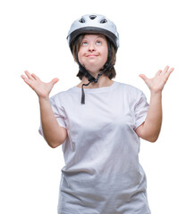 Young adult cyclist woman with down syndrome wearing safety helmet over isolated background crazy and mad shouting and yelling with aggressive expression and arms raised. Frustration concept.
