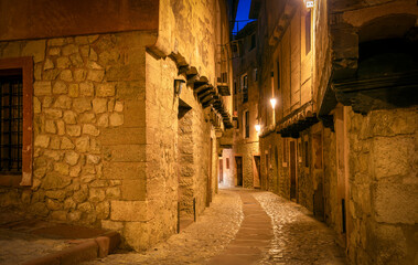 Typical medieval street illuminated at dusk in the artistic historic center of Albarracín, Teruel,...