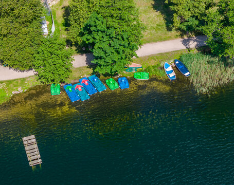 Aerial view of pedal boats parked on the shore of Galve lake, Trakai, Lithuania. Top up view of hydrocycle water bikes