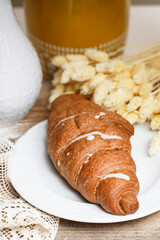 French croissant made of puff pastry on a wooden table.