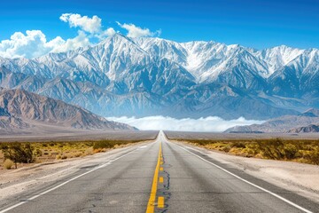 Fototapeta premium Asphalt Road Leading to Snowy Mountain Range