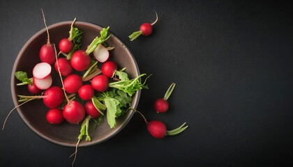 Radish in a bowl on a black background, top view, copy space 