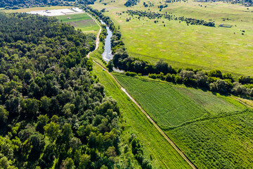 River bed passing by rural fields and forests, bird's eye view