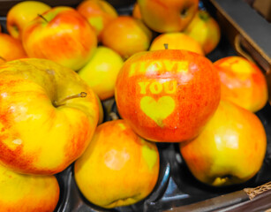 Apple in a full box of apples with I love You text sign on it. Special apples grown for Valentine's day