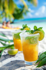 Fototapeta premium Two glasses of a drink with lime slices on the side