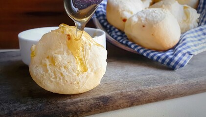 Honey dripping in motion on cheese bread, typical Brazilian food. Hoizontal photo