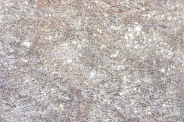 Background made of white shiny fabric with sequins.