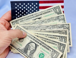 Notas de dolares em diversos valores com fundo branco e bandeira dos Estados Unidos da America.