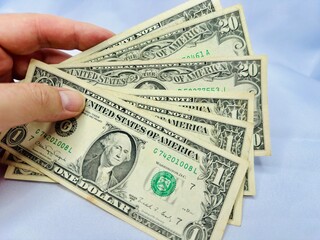 Notas de dolares em diversos valores com fundo branco e bandeira dos Estados Unidos da America.