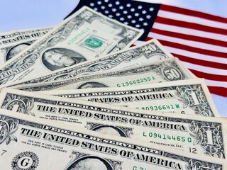 Dolares com bandeira dos Estados unidos no fundo.