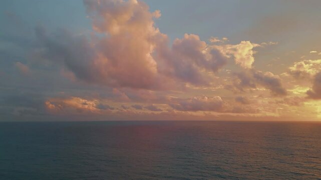Cloudy sky golden sunset over tranquil ocean water aerial view. Serene evening