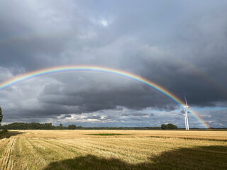 Rainbow Over Countryside Landscape with Cloudy Sky Green Meadow Bright Colors Summer Storm Scenic View Horizon Fresh Spring Day