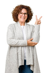 Beautiful middle ager senior woman wearing jacket and glasses over isolated background smiling with...
