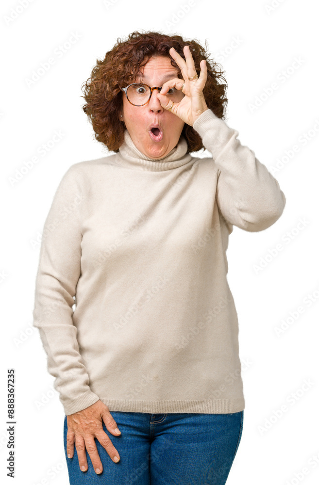 Canvas Prints Beautiful middle ager senior woman wearing turtleneck sweater and glasses over isolated background doing ok gesture shocked with surprised face, eye looking through fingers. Unbelieving expression.