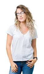Beautiful young blonde woman wearing glasses over isolated background winking looking at the camera...