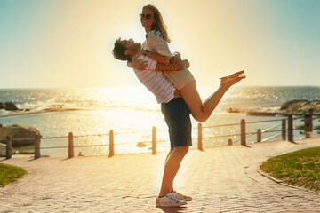 Couple, love and lifting with smile outdoor for anniversary celebration, support and hug of romance...