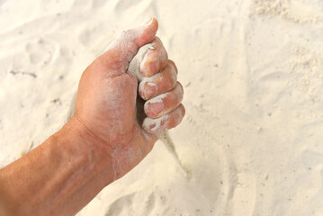 Man holding and put the sand through hand. Time concept.
