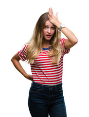 Obraz premium Young beautiful blonde woman over isolated background surprised with hand on head for mistake, remember error. Forgot, bad memory concept.