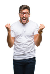 Young handsome man wearing glasses over isolated background celebrating surprised and amazed for success with arms raised and open eyes. Winner concept.