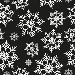 Winter seamless pattern of white textured snowflakes on a black background. Chalk on a blackboard. Seasonal vector illustration.