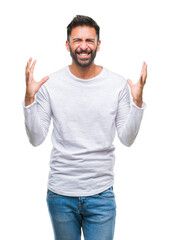 Adult hispanic man over isolated background crazy and mad shouting and yelling with aggressive expression and arms raised. Frustration concept.