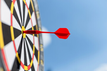 red dart hit a target on a blue sky with clouds. Target and successful hit, concept. Marketing and...
