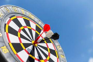 Three darts hitting the target on a blue sky background, concept. Marketing and successful targeting