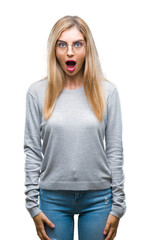 Young beautiful blonde woman wearing glasses over isolated background afraid and shocked with surprise expression, fear and excited face.