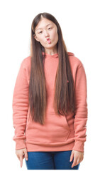 Obraz premium Young Chinese woman over isolated background wearing sport sweathshirt making fish face with lips, crazy and comical gesture. Funny expression.