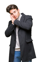 Young elegant man wearing winter coat over isolated background sleeping tired dreaming and posing with hands together while smiling with closed eyes.