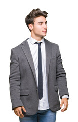 Young business man wearing suit and tie over isolated background looking away to side with smile on face, natural expression. Laughing confident.