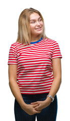 Young caucasian woman over isolated background looking away to side with smile on face, natural expression. Laughing confident.