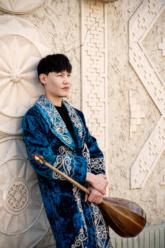Kazakh man in national ethnic costume with chapan and dombra