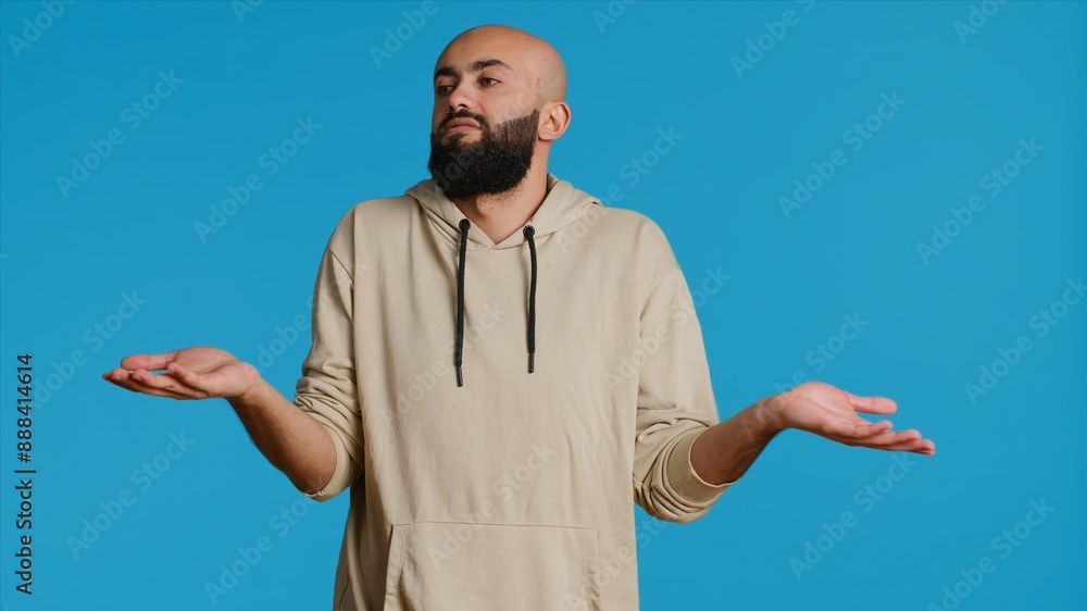 Poster middle eastern guy showing i dont know gesture in studio, being clueless and uncertain about answer 